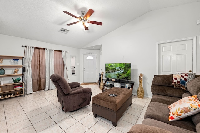 living area featuring visible vents, light tile patterned flooring, ceiling fan, and high vaulted ceiling
