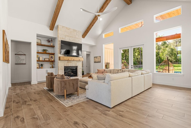 8577 Majestic Lake Ct, Montgomery, TX 77316 - living area featuring beam ceiling, a stone fireplace, baseboards, light wood-type flooring, and high vaulted ceiling