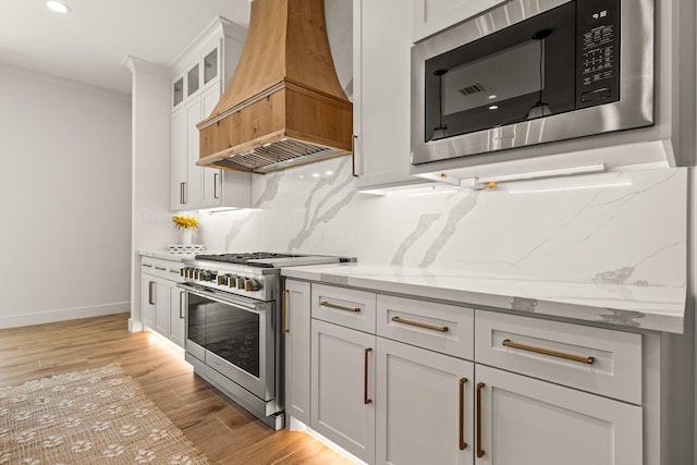 8577 Majestic Lake Ct, Montgomery, TX 77316 - kitchen with stainless steel appliances, custom range hood, backsplash, light stone counters, and crown molding