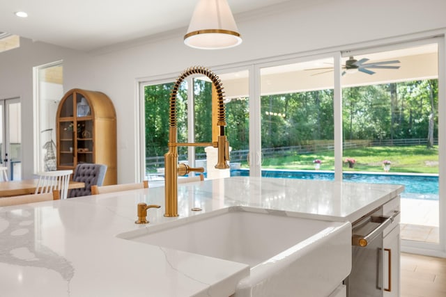 8577 Majestic Lake Ct, Montgomery, TX 77316 - kitchen with a sink, plenty of natural light, light stone counters, ceiling fan, and ornamental molding