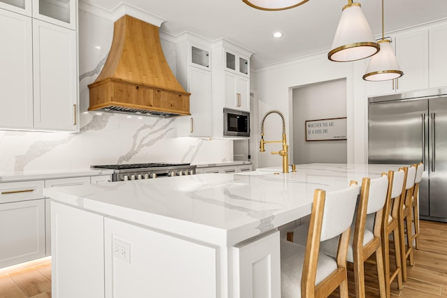 8577 Majestic Lake Ct, Montgomery, TX 77316 - kitchen featuring custom range hood, built in appliances, a center island with sink, recessed lighting, and light wood-type flooring