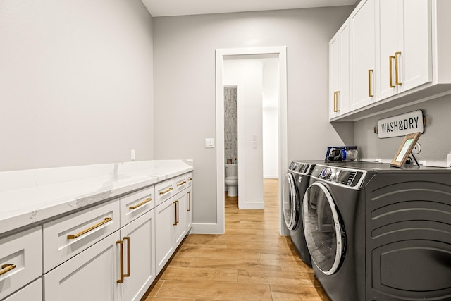 8577 Majestic Lake Ct, Montgomery, TX 77316 - laundry room featuring cabinet space, washing machine and clothes dryer, light wood-type flooring, and baseboards