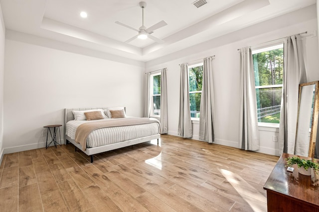 8577 Majestic Lake Ct, Montgomery, TX 77316 - bedroom with a raised ceiling, light wood-style floors, baseboards, and a ceiling fan