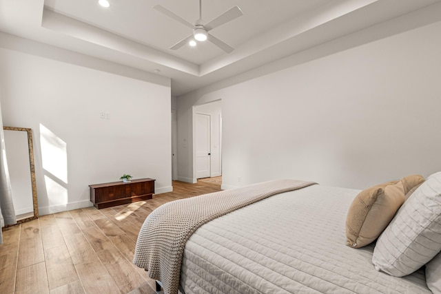 8577 Majestic Lake Ct, Montgomery, TX 77316 - bedroom with light wood-type flooring, recessed lighting, baseboards, a tray ceiling, and a ceiling fan