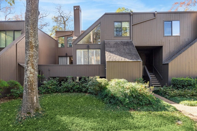 167 Litchfield Ln, Houston, TX 77024 - back of house featuring stairway, a yard, and a chimney