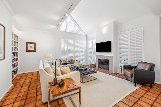 167 Litchfield Ln, Houston, TX 77024 - tiled living area featuring rail lighting, baseboards, a fireplace with flush hearth, and vaulted ceiling