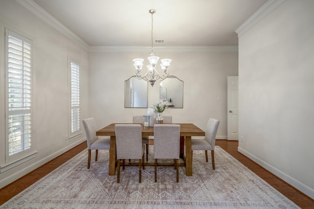 dining room featuring a chandelier, plenty of natural light, ornamental molding, and baseboards