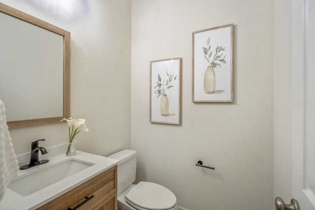 half bathroom featuring toilet and vanity