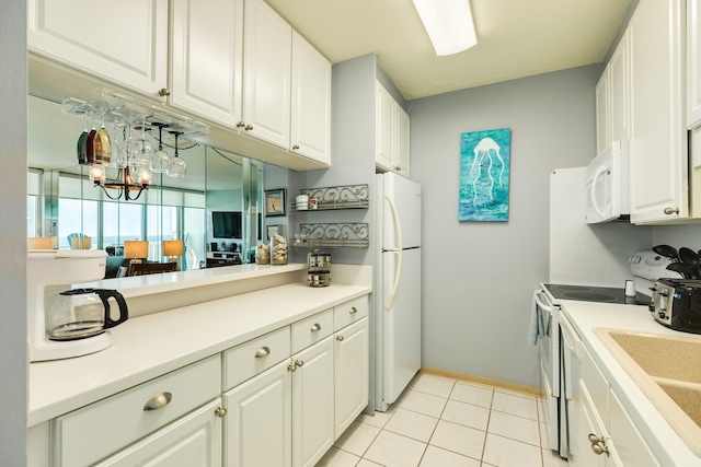1401 E Beach Dr Unit 811, Galveston, TX 77550 - kitchen featuring a sink, white appliances, light tile patterned flooring, white cabinetry, and light countertops