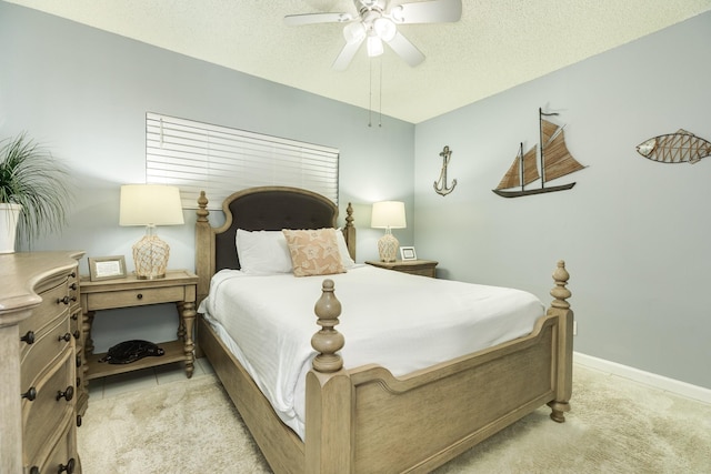 1401 E Beach Dr Unit 811, Galveston, TX 77550 - bedroom with light carpet, a textured ceiling, baseboards, and ceiling fan