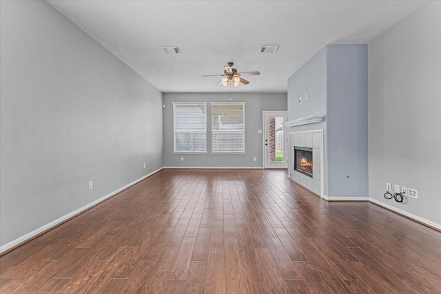 unfurnished living room with visible vents, wood finished floors, baseboards, and ceiling fan