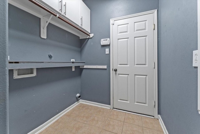 doorway featuring baseboards and light tile patterned floors