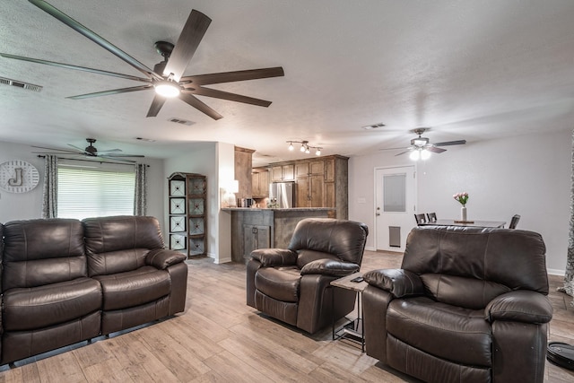 living room with a ceiling fan, baseboards, light wood-type flooring, and visible vents