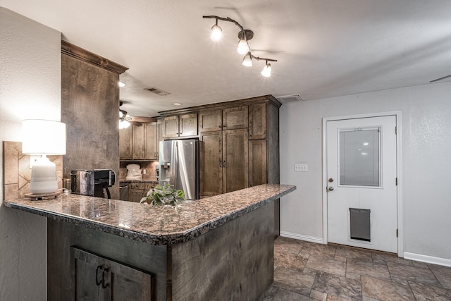 kitchen with a peninsula, visible vents, baseboards, and stainless steel refrigerator with ice dispenser