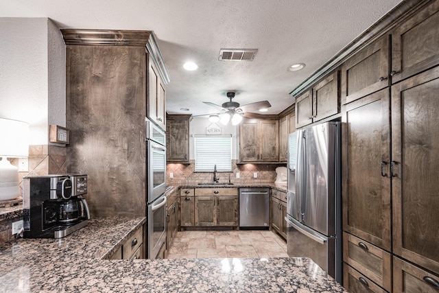 kitchen featuring backsplash, stainless steel appliances, visible vents, and a sink