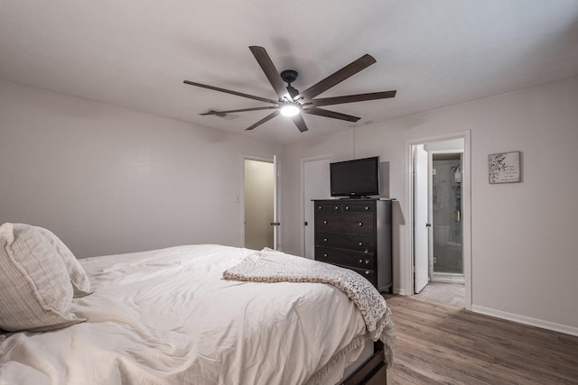bedroom featuring connected bathroom, wood finished floors, a ceiling fan, visible vents, and baseboards