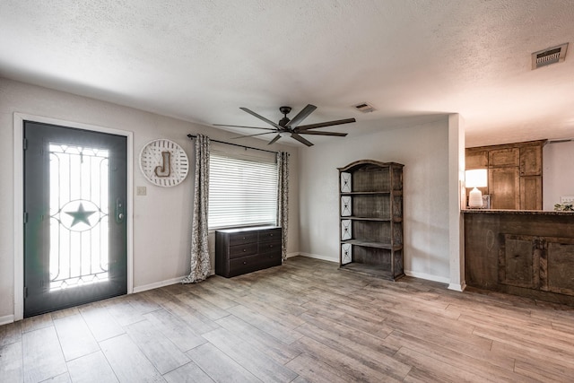 entrance foyer featuring a ceiling fan, visible vents, and a textured ceiling
