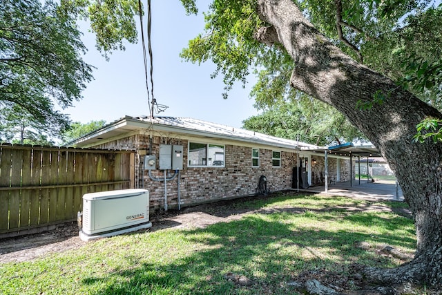 back of property featuring a yard, fence, and brick siding