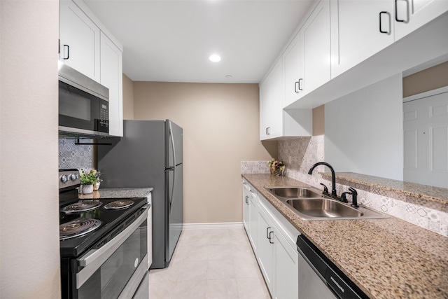 kitchen featuring backsplash, appliances with stainless steel finishes, baseboards, and a sink