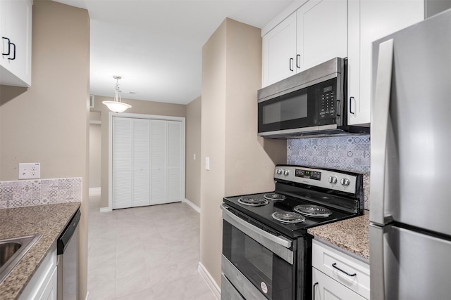 kitchen with stainless steel appliances, light stone counters, white cabinetry, decorative backsplash, and baseboards