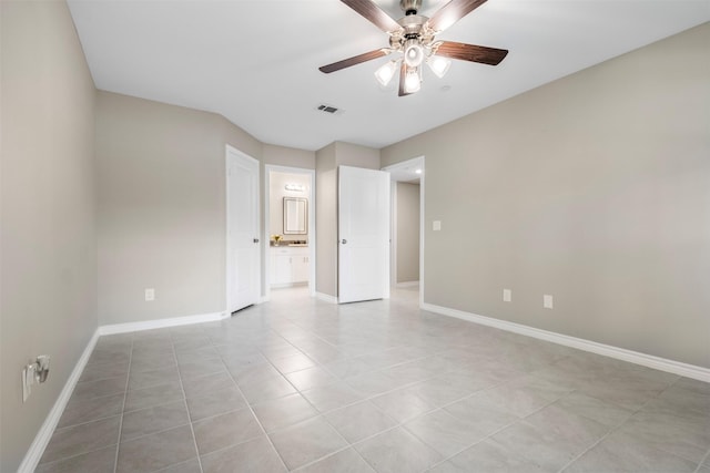 unfurnished bedroom with connected bathroom, a ceiling fan, visible vents, baseboards, and light tile patterned flooring