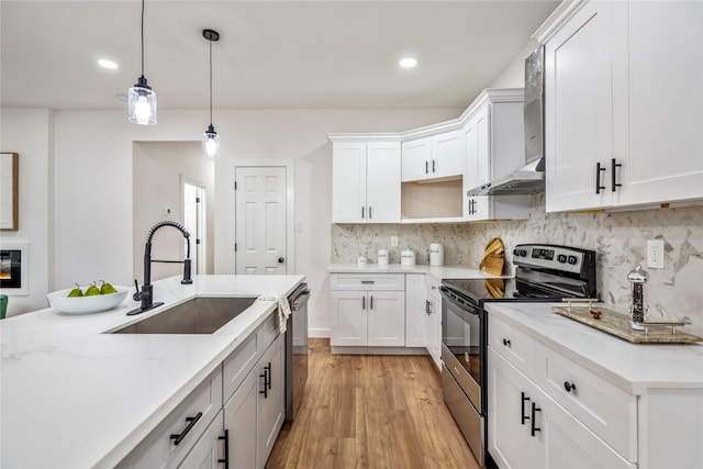 4104 Engelke St, Houston, TX 77003 - kitchen with hanging light fixtures, light wood finished floors, a sink, appliances with stainless steel finishes, and tasteful backsplash