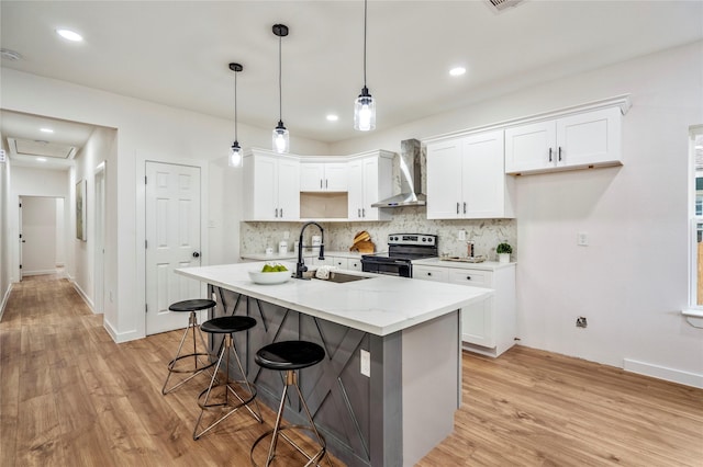 4104 Engelke St, Houston, TX 77003 - kitchen with a sink, wall chimney range hood, electric stove, white cabinetry, and light wood-style floors