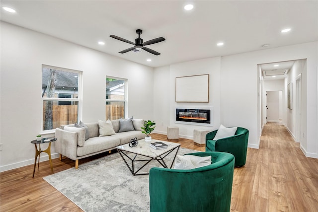 4104 Engelke St, Houston, TX 77003 - living room with a ceiling fan, recessed lighting, baseboards, light wood finished floors, and a glass covered fireplace