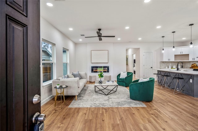 4104 Engelke St, Houston, TX 77003 - living room with baseboards, light wood finished floors, a glass covered fireplace, and ceiling fan
