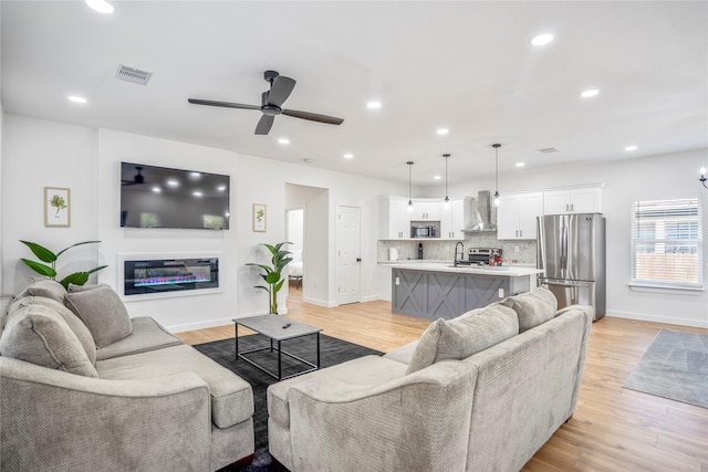 4104 Engelke St, Houston, TX 77003 - living area featuring light wood finished floors, a ceiling fan, visible vents, baseboards, and recessed lighting