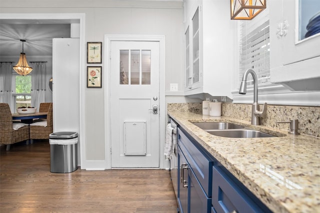 419 E Bell Ave, Crockett, TX 75835 - kitchen with a sink, blue cabinets, dark wood-type flooring, an inviting chandelier, and glass insert cabinets