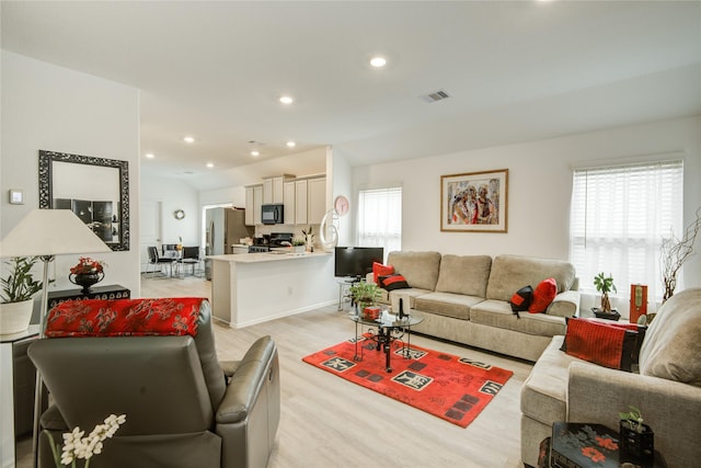 living area featuring recessed lighting, light wood-style floors, and visible vents