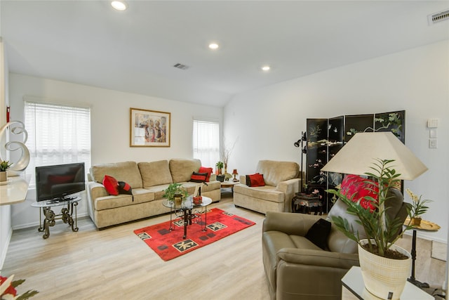 living room with recessed lighting, visible vents, and wood finished floors
