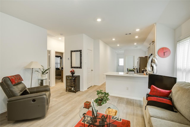 living area with visible vents, light wood-style flooring, baseboards, and recessed lighting