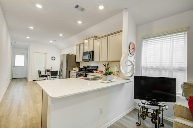kitchen featuring a peninsula, light stone counters, light wood-type flooring, visible vents, and appliances with stainless steel finishes