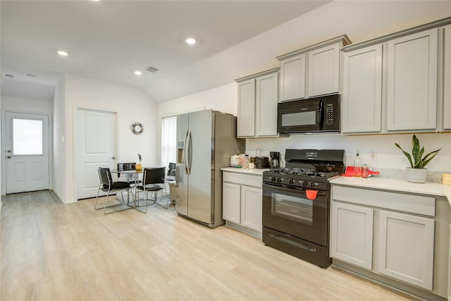 kitchen featuring light countertops, plenty of natural light, visible vents, and black appliances