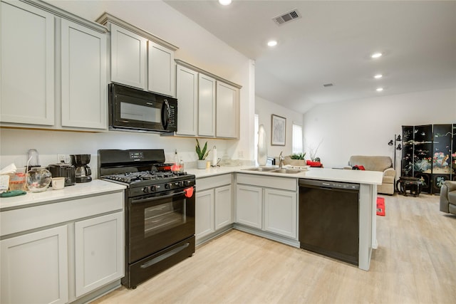 kitchen featuring a peninsula, a sink, open floor plan, visible vents, and black appliances