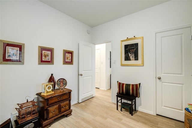 living area featuring light wood-style flooring and baseboards