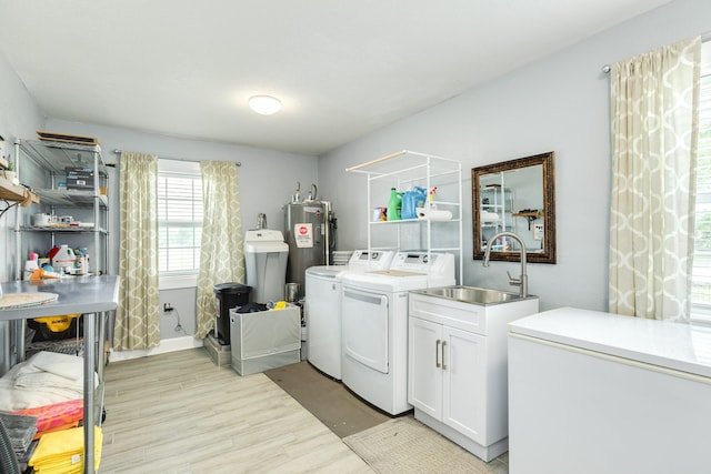 clothes washing area with washer and dryer, light wood-style flooring, a sink, cabinet space, and water heater