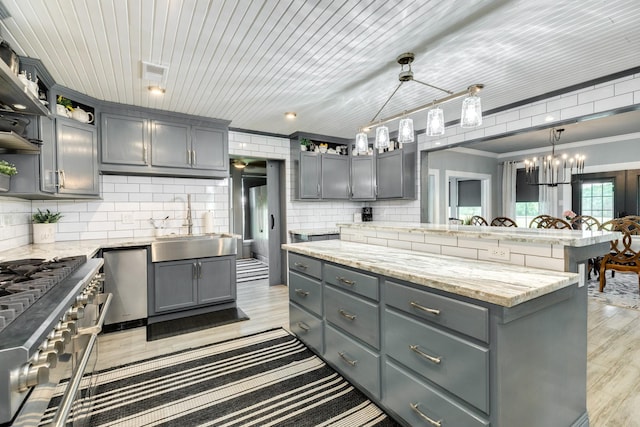 kitchen with gray cabinetry, double oven range, an inviting chandelier, open shelves, and tasteful backsplash