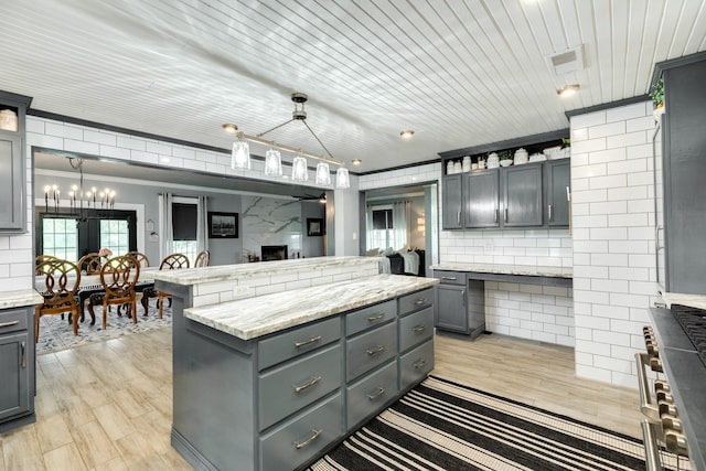 kitchen featuring decorative backsplash, a center island, pendant lighting, and gray cabinets