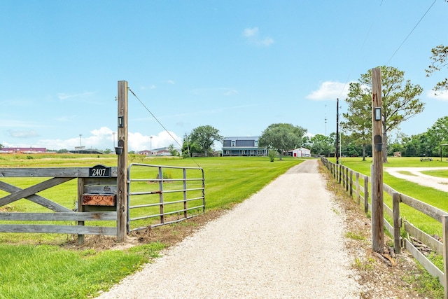 view of road featuring a gated entry, a rural view, and driveway