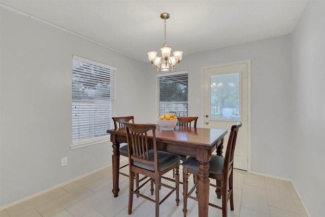 dining space with baseboards, a wealth of natural light, and a chandelier