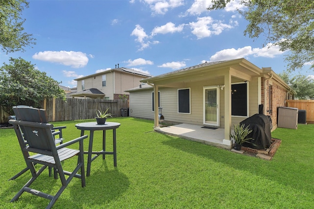 back of house featuring a fenced backyard, a patio area, central AC, and a lawn