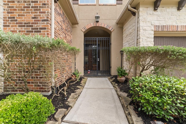 17803 Netherby Ln, Richmond, TX 77407 - entrance to property with stone siding, a gate, stucco siding, and brick siding