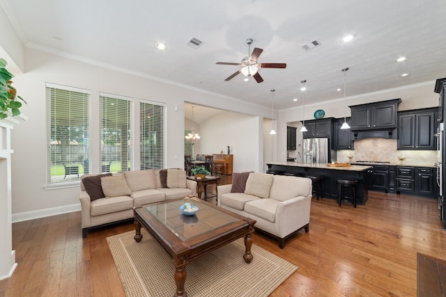 17803 Netherby Ln, Richmond, TX 77407 - living room featuring ceiling fan, light wood finished floors, recessed lighting, crown molding, and a chandelier