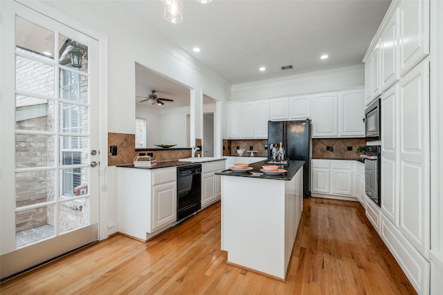 2827 Briarhurst Park, Houston, TX 77057 - kitchen with dark countertops, white cabinetry, visible vents, black appliances, and ornamental molding