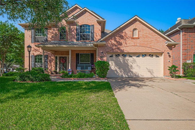 traditional home with brick siding, driveway, a garage, covered porch, and a front yard