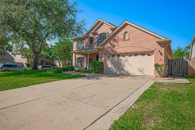 traditional-style home with brick siding, an attached garage, driveway, and a gate