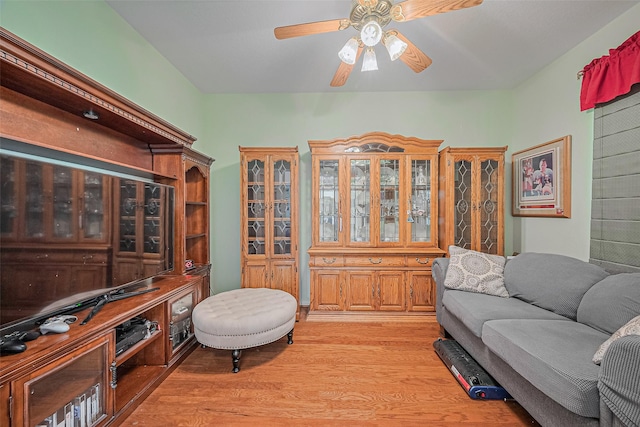 living area featuring light wood-type flooring and ceiling fan
